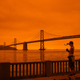 A runner takes a picture of the Bay Bridge in San Francisco under smoke-clogged skies.
